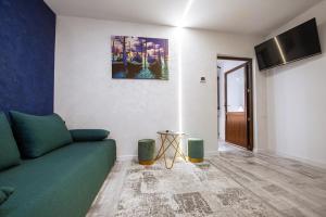 a living room with a green couch and a tv at Vila H2O in Mangalia
