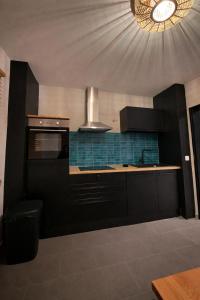 a kitchen with black cabinets and a clock on the ceiling at stayOldenburg in Oldenburg +12 photos