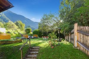 un patio trasero con una valla y un patio de césped en Hotel Gasthof Adler, en Sankt Gallenkirch