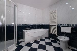 
a bathroom with a tub, toilet and sink at Hotel Parma & Congressi in Parma
