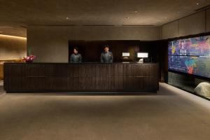 two people standing at a counter in a hotel lobby at THE HOTEL HIGASHIYAMA KYOTO TOKYU, A Pan Pacific Hotel in Kyoto