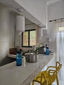 a kitchen with a counter top with two yellow chairs at Casalola in Mombasa