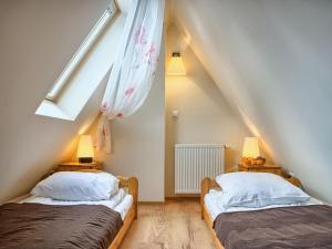 two beds in a attic bedroom with a roof at VisitZakopane - Olymp Apartament in Zakopane
