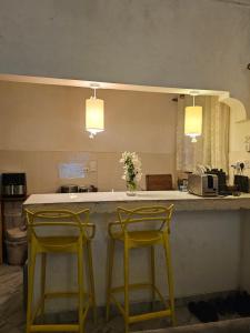 two yellow stools sitting at a counter in a kitchen at Casalola in Mombasa +20 photos