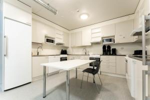a white kitchen with a table and a chair at LODGE Hostel Ylläs in Äkäslompolo