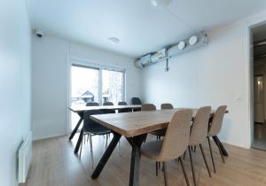 a dining room with a wooden table and chairs at LODGE Hostel Ylläs in Äkäslompolo +7 photos