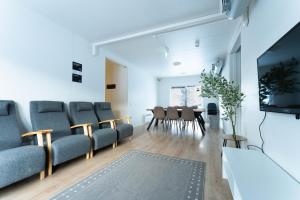 a living room with chairs and a tv and a table at LODGE Hostel Ylläs in Äkäslompolo