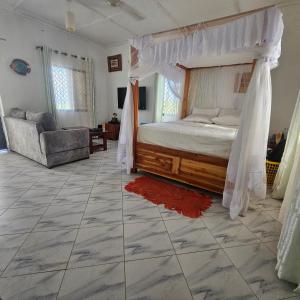 a bedroom with a canopy bed and a tiled floor at Casalola in Mombasa