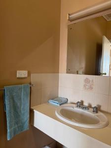 a bathroom with a sink and a mirror at Cadney Park Accommodation in Coober Pedy +16 photos