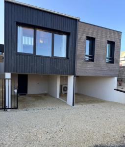 a modern house with a black roof at Lodges des Pontons - Cap Ouest - vue mer in Saint-Côme-de-Fresné