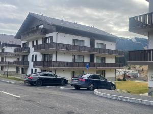 two cars parked in a parking lot in front of a building at Mountain Whisper Chalet in Braşov