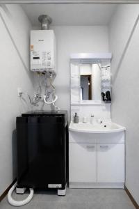 a white bathroom with a sink and a mirror at Hills Niseko B in Niseko +82 photos