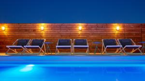 a group of blue chairs sitting next to a wooden fence at Delamar 4*Sup-Adults only (18+) in Lloret de Mar