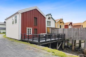 a red and white building next to a fence at Brygge Sjøgata in Mosjøen +2 photos