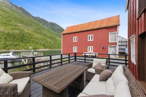 a balcony with a table and chairs and a red building at Brygge Sjøgata in Mosjøen