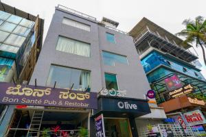 a tall building with a sign in front of it at Olive Zip Rest House Road by Embassy Group in Bangalore