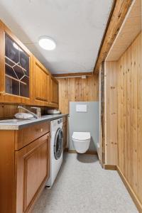 a bathroom with a washing machine and a toilet at Brygge Sjøgata in Mosjøen