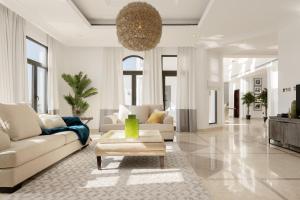 a living room with a couch and a table at Maison Privee - Villa on Beach with Private Pool The Palm Jumeirah in Dubai