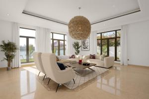 a living room with white furniture and a chandelier at Maison Privee - Villa on Beach with Private Pool The Palm Jumeirah in Dubai