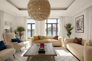 a living room with couches and a chandelier at Maison Privee - Villa on Beach with Private Pool The Palm Jumeirah in Dubai