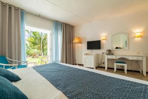 a hotel room with a bed and a window at Casuarina Resort and Spa in Trou aux Biches