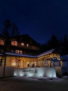 a building covered in lights in the snow at night at Lärchen Lodge in Oberwald