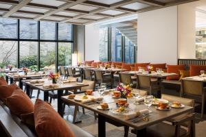 a restaurant with tables and chairs and large windows at THE HOTEL HIGASHIYAMA KYOTO TOKYU, A Pan Pacific Hotel in Kyoto