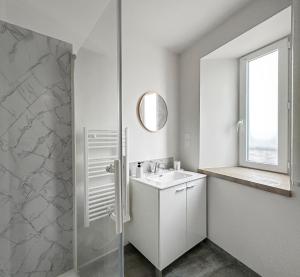 a white bathroom with a sink and a shower at Appartement moderne et lumineux avec parking privé in Vierzon +15 photos