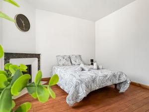 a bedroom with a bed and a clock on the wall at Appartement moderne et lumineux avec parking privé in Vierzon