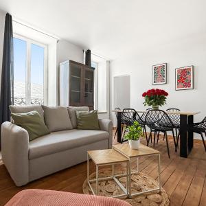 a living room with a couch and a table at Appartement moderne et lumineux avec parking privé in Vierzon