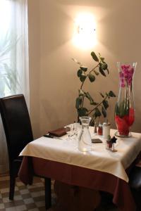 a table with a vase on top of it at Logis Hôtel Restaurant de la Dore in Vertolaye