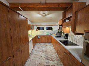 a large kitchen with wooden cabinets and white appliances at Ferienwohnung Bergherz in Sankt Johann im Walde