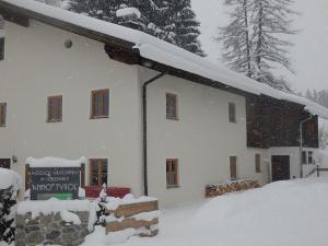 un edificio cubierto de nieve con un cartel delante en anno Tyrol en Biberwier