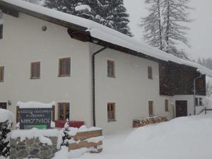 ein schneebedecktes Gebäude mit einem Schild davor in der Unterkunft anno Tyrol in Biberwier