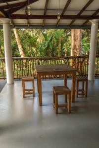 a wooden picnic table and stool on a porch at Green Serenity Villa in Ahangama +14 photos
