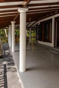 a row of white columns in a building with tables at Green Serenity Villa in Ahangama