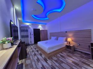 a bedroom with a white bed and a blue ceiling at Aasna Inn in Thulusdhoo