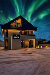 a building with the northern lights in the sky at Hvanndalir Lodge in Ólafsfjörður