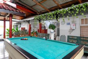 a pool table in the middle of a room at RedDoorz near Jawa Timur Park 1 in Batu