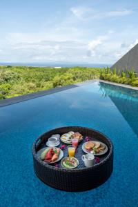 a tray of food on top of a swimming pool at Khaya Luxury Villas Nusa Dua in Nusa Dua