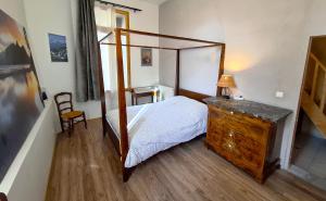 a bedroom with a canopy bed and a wooden dresser at VILLA SEQUOIA in Jausiers