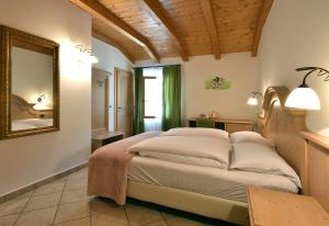 a bedroom with a bed with a mirror and a table at Agritur Campo Fiorito in Dro