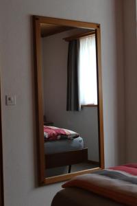 espejo en un dormitorio con cama y ventana en Hus Pravis, en Klosters