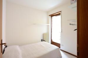 sypialnia z łóżkiem i oknem w obiekcie Apart Erica w mieście Comano Terme