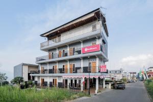 a building with balconies on the side of a street at RedDoorz at Omahku Guest House Batu in Malang