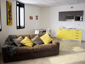 a living room with a brown couch with yellow pillows at Residenze Parmensi in Castelguelfo
