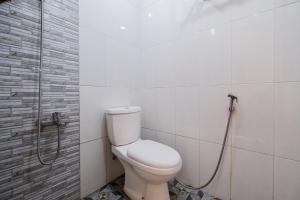 a bathroom with a toilet and a shower at RedDoorz at Omahku Guest House Batu in Malang