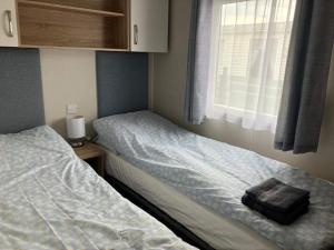 a small bedroom with two beds and a window at Moray Coast getaway in Lossiemouth