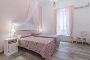 una camera con due letti e un lampadario a braccio di Le Villanelle B&B a Napoli