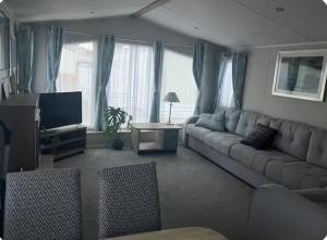 a living room with a couch and a tv at Moray Coast getaway in Lossiemouth